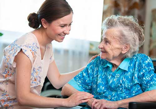 Nurse talking with female resident in wheelchair