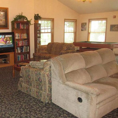 Common area with tv, books, couches and a pool table