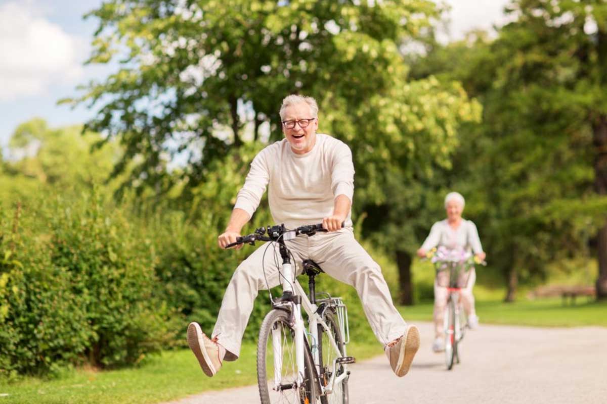 Man and woman riding bikes in park